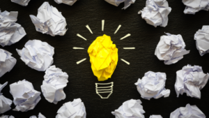 ideia criativa no marketing digital simbolizada por lâmpada feita de papel amassado amarelo