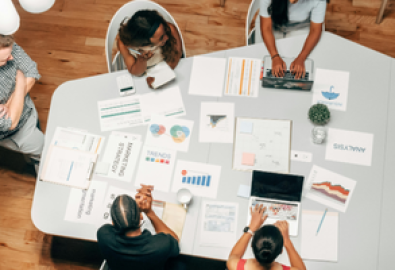 Equipe de marketing reunida desenvolvendo estratégia de SEO on page com gráficos e análise de dados sobre a mesa